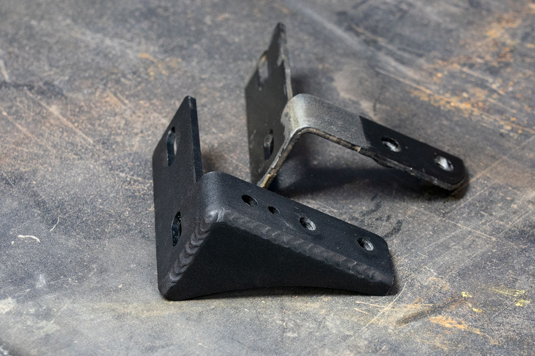 BAJA NORTE HIGH CLEARANCE REAR LOWER SHOCK BRACKETS for Sprinter 2500 (2007-Present) by VAN COMPASS, showing metal brackets designed for increased ground clearance and reinforced shock mounts.