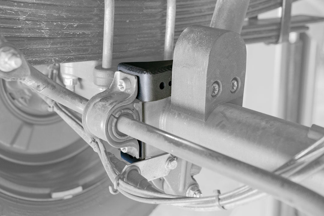 Close-up of Baja Sur Heavy Duty Rear Lower Shock Brackets for Sprinter 2500, showcasing robust steel construction and reinforcement design by Van Compass.