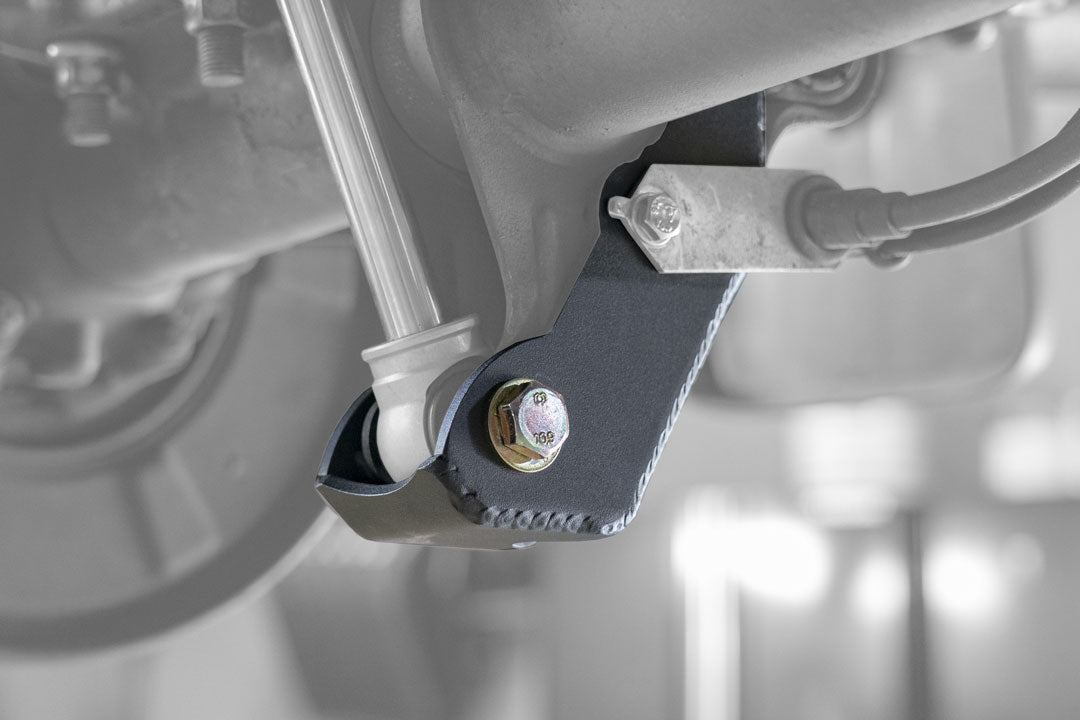 BAJA SUR Heavy Duty Rear Lower Shock Brackets for Sprinter 2500, showing close-up of laser-cut, reinforced metal brackets designed to protect and strengthen the van's shock mount.