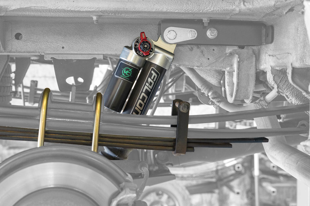 Close-up of the Stage 4.3 System by Van Compass, showcasing adjustable Falcon 3.3 shocks with a Fast Adjust knob and 3-leaf mini spring pack for Sprinter AWD, 4x4 (2015-Present 2500 only).