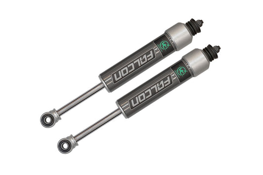 Pair of Falcon 2.1 monotube front shocks for Sprinter 4x4, featuring black rubber caps and grey cylinders, designed by Van Compass for improved vehicle handling.