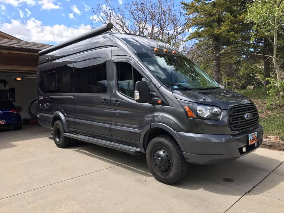 TERRAIN 2 REAR LIFT KIT - TRANSIT (2015+) by VAN COMPASS installed on a grey van parked in a driveway, showcasing enhanced suspension and ground clearance.