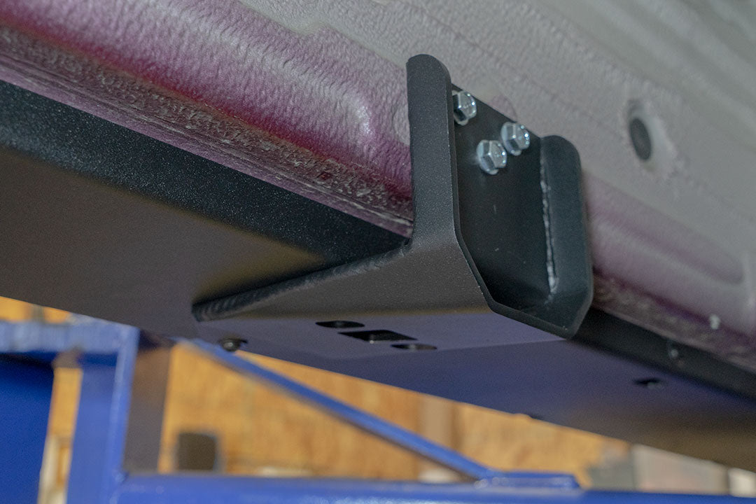 Rocker Guards - Sprinter 4x4 (2015-2022 170 Wheelbase Only) by Van Compass, showing a metal bracket with bolts and screws, enhancing chassis rigidity and access.