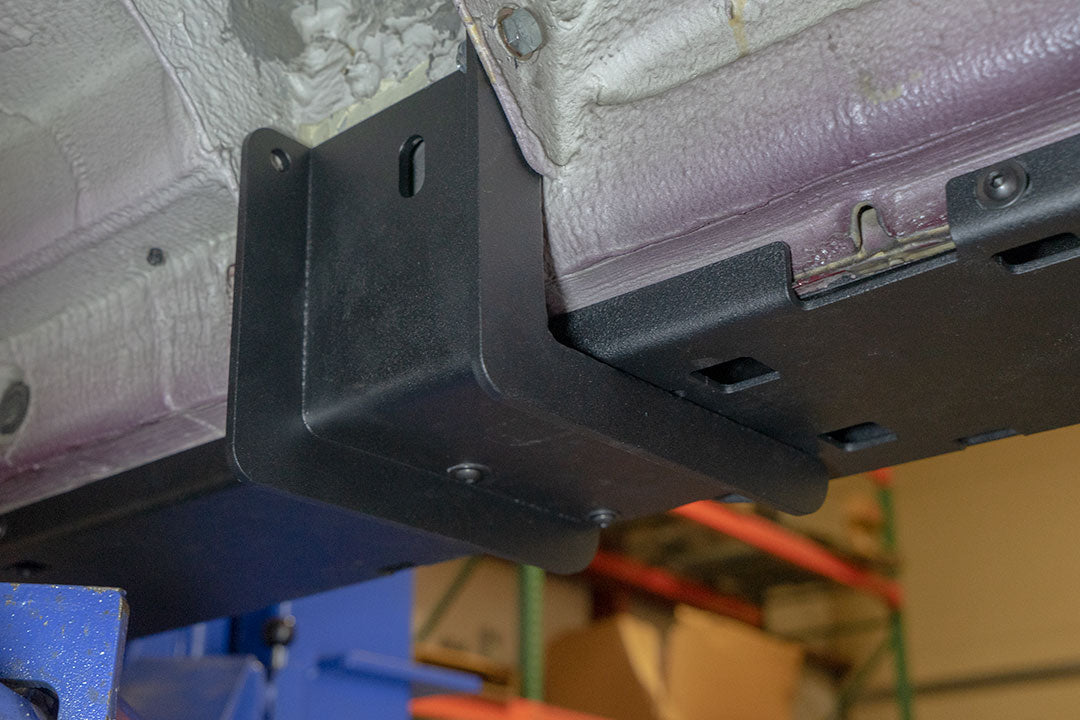 Rocker Guards for Sprinter 4x4, featuring a metal bracket on a wall with visible bolts, offering robust chassis rigidity and easy access.