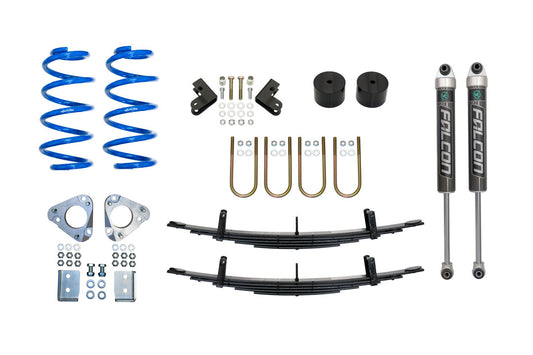 Stage 3 Topo 2.0 System for Transit AWD by Van Compass, featuring blue springs, black cylinders, metal parts, and shock relocation brackets for enhanced vehicle performance.