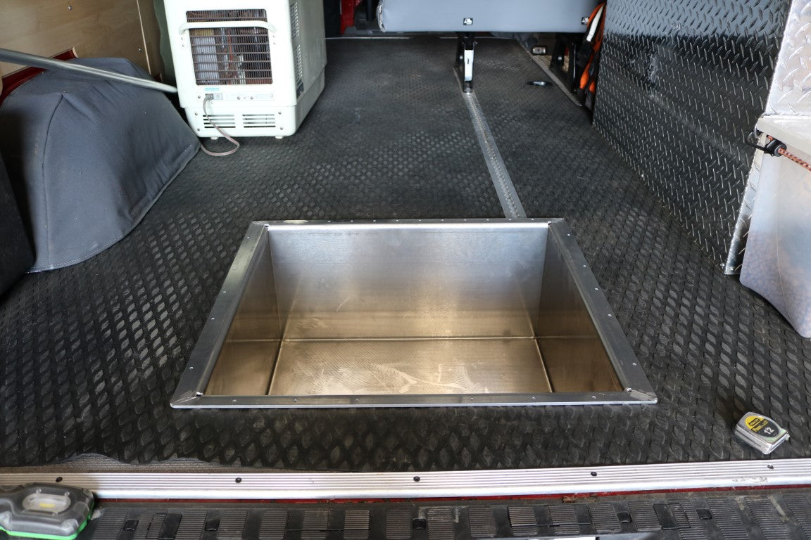 Rear Storage Trunk - Sprinter (2007+) by Van Compass, a metal storage box designed for van undercarriage, enhancing storage and functionality, shown on a black surface.