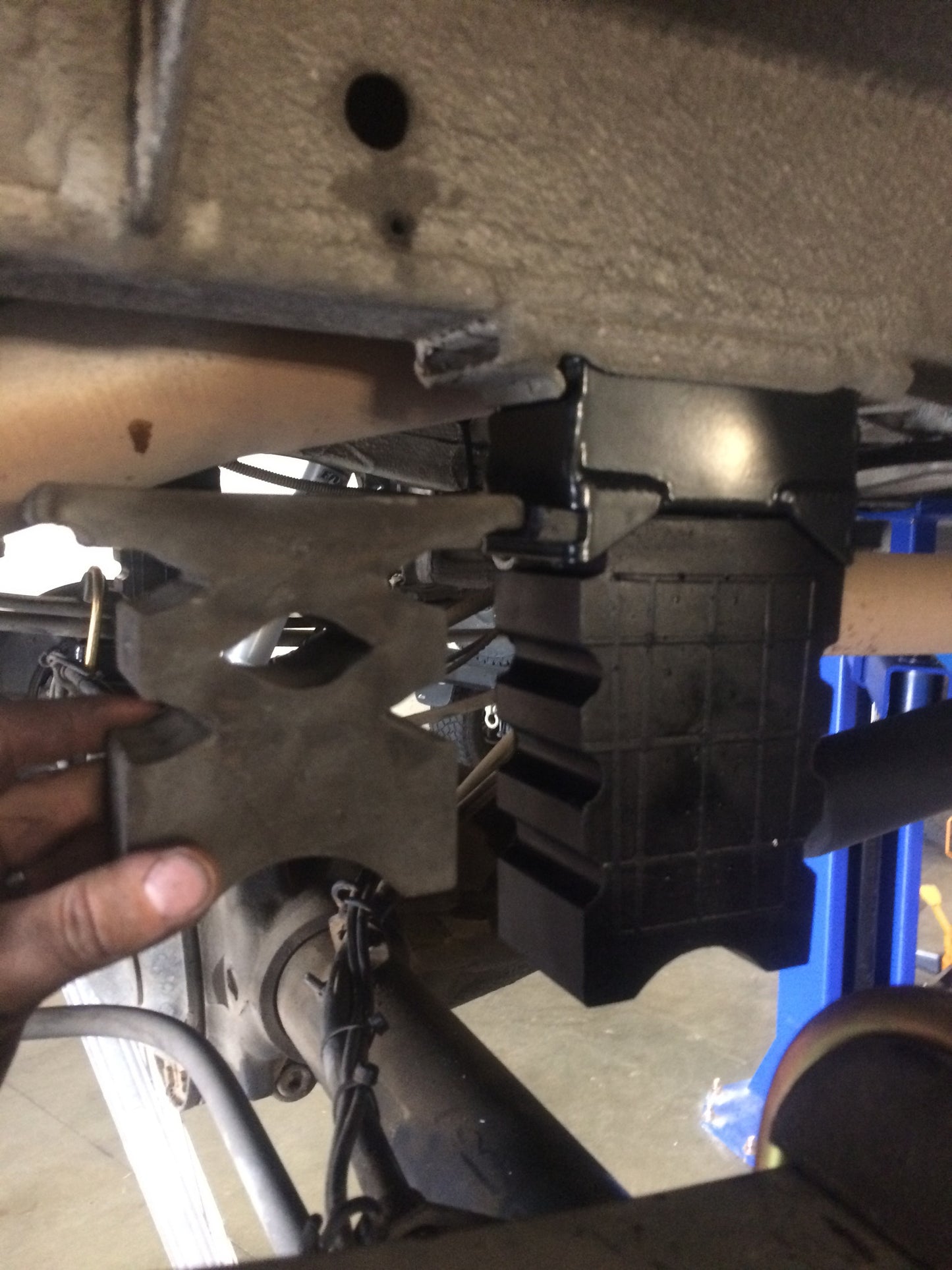 Hand holding Sumo Spring Rear Bump Stops - Sprinter (1994+ 2500 Only) Pair, showcasing the metal object designed for improved vehicle suspension and control.