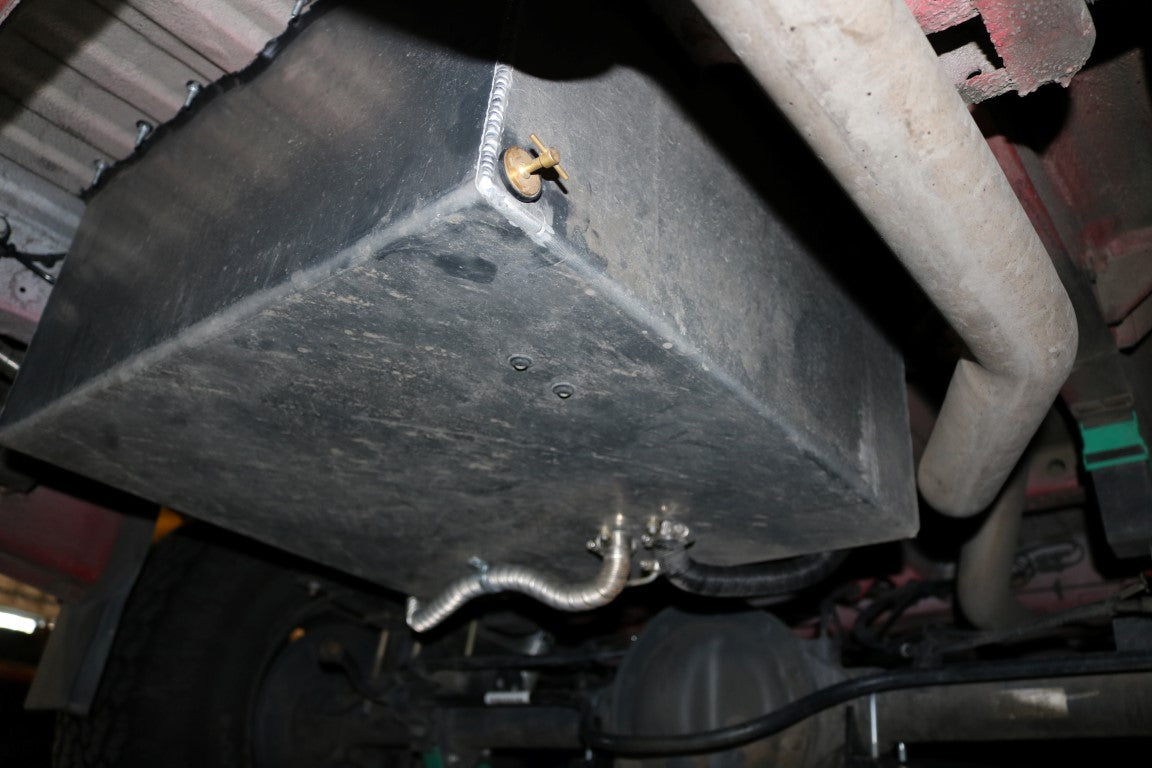 Rear Storage Trunk - Sprinter (2007+) by Van Compass, a sturdy metal box with a screw and hose, designed for added storage beneath the vehicle.